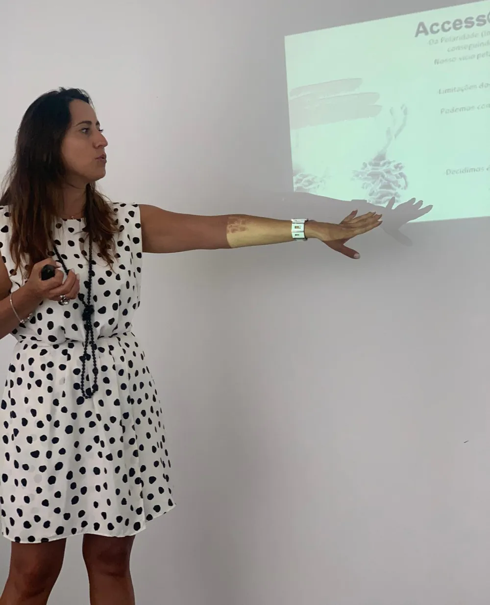 A Ana a dar uma formação de Barras de Access®, a apontar para a projeção na parede